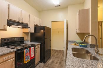 a kitchen with black appliances and granite counter tops